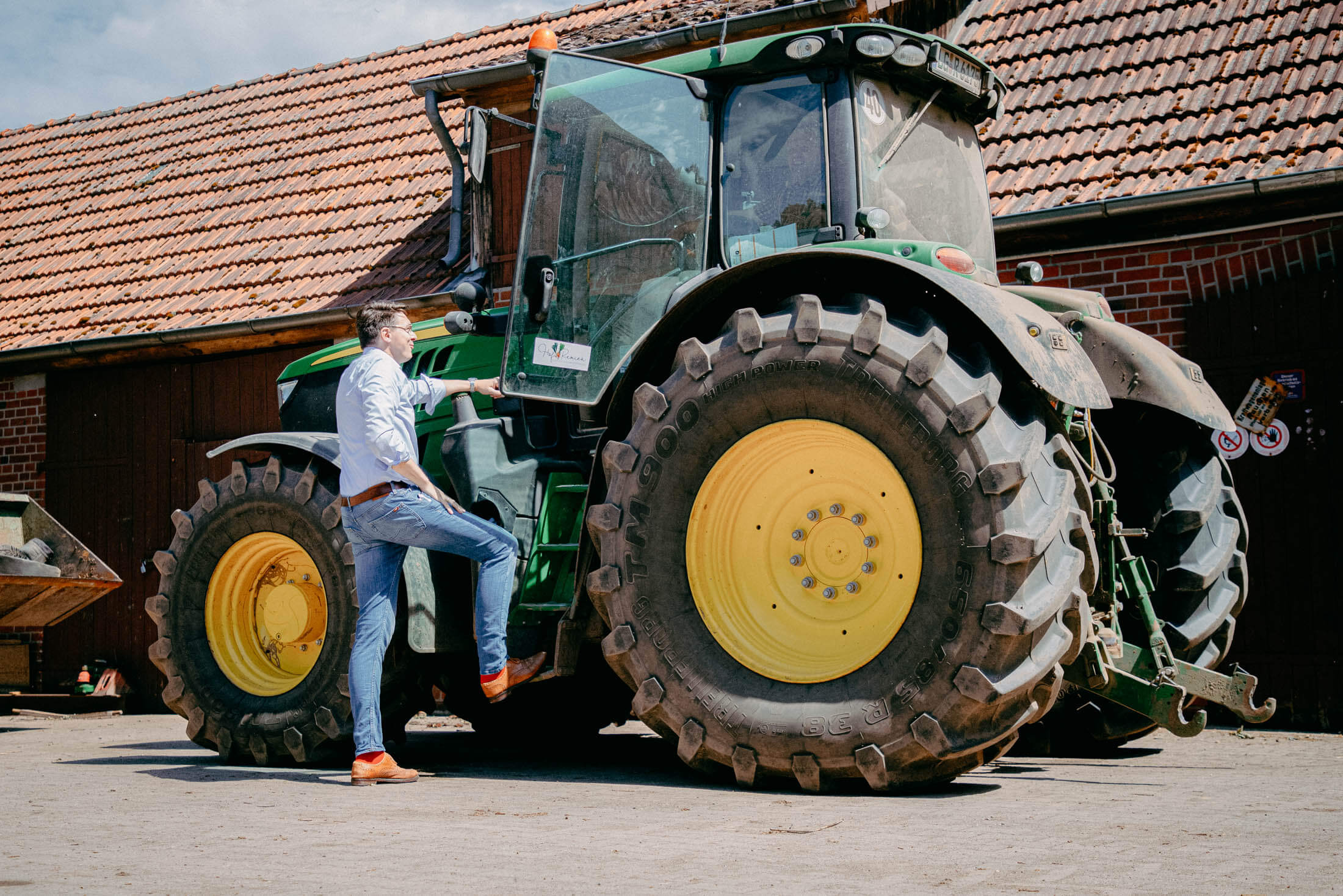 Arnd Steinmeyer Anwalt für Agrarecht, Kanzlei Berburg, unterhält sich mit Landwirt auf einem Bauernhof am Traktor